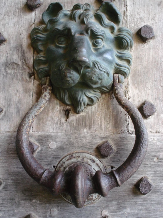 an old door knockle and iron lions head