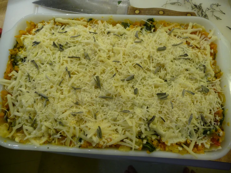 a cheese dish in a casserole dish on a  board