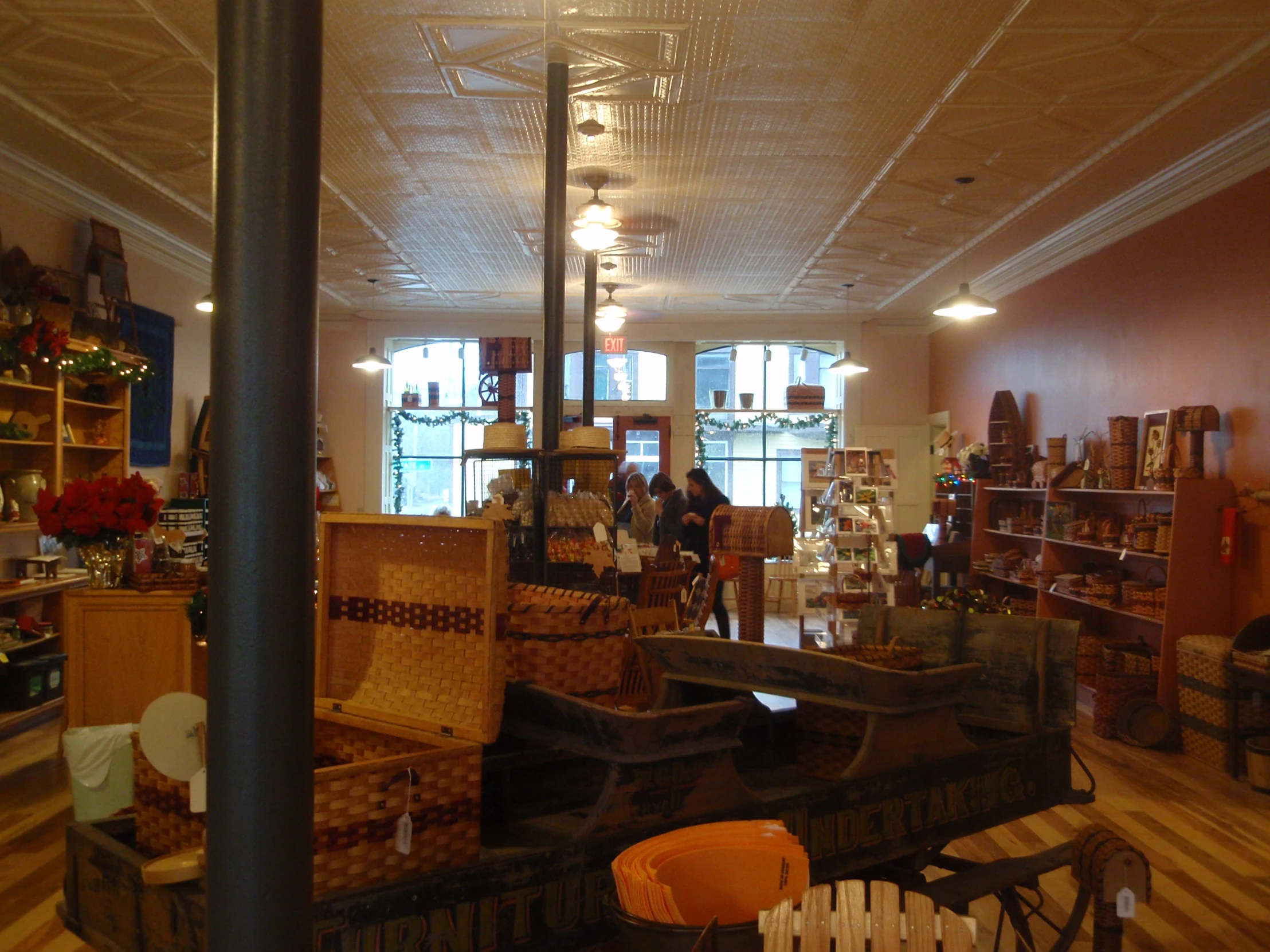 a shop with boxes, baskets and several people in it