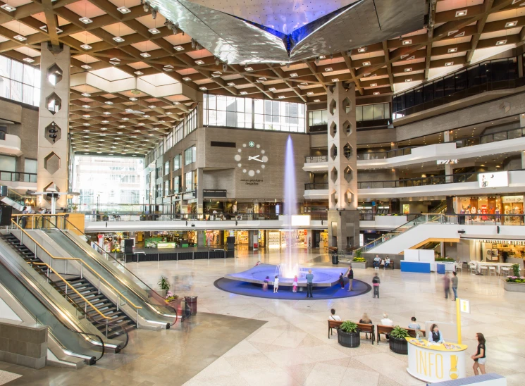 large shopping mall with multiple levels, benches and an open atrium