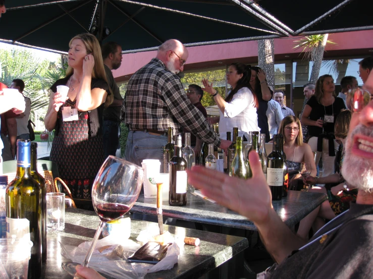 many people are at an outdoor wine tasting event