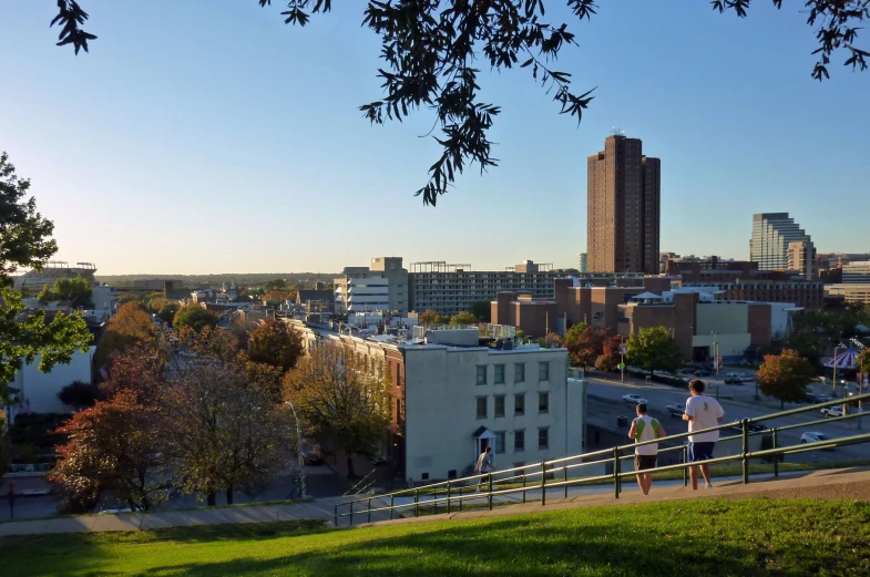 people walk on the edge of a walkway looking over buildings