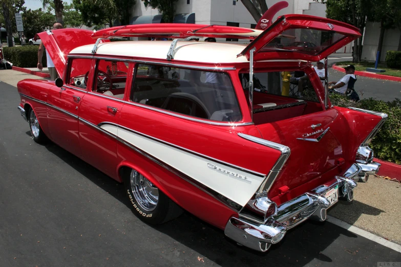 a red, white and grey old fashion car is parked