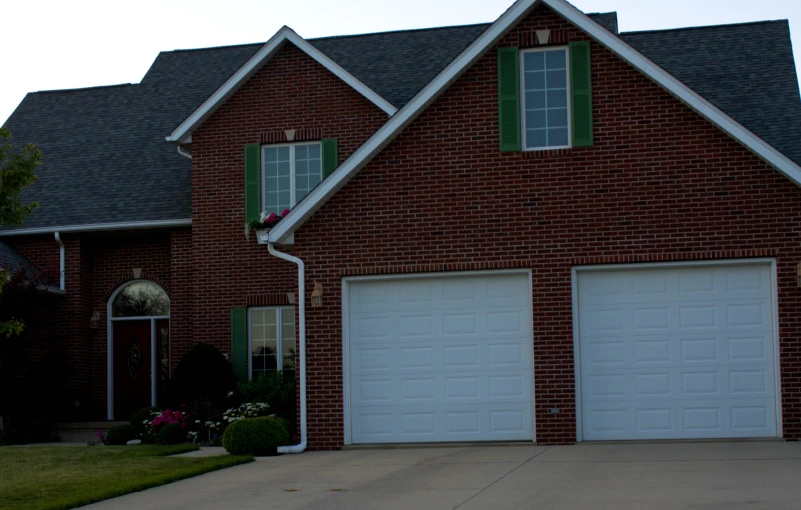 a couple of garage doors sitting outside a house