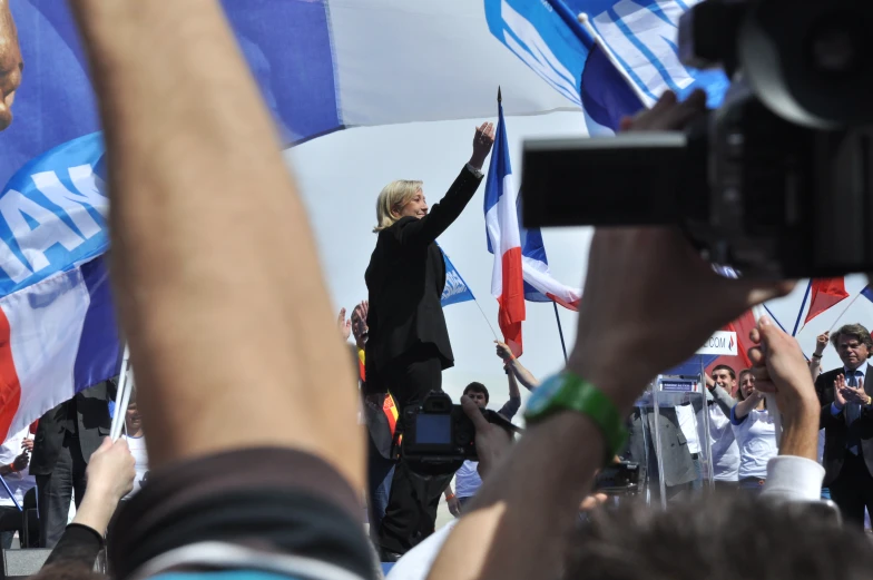 a crowd of people raising their hands in the air