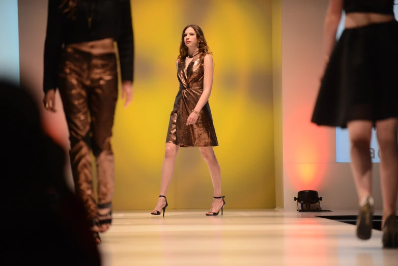 a person in a dress walking on a runway