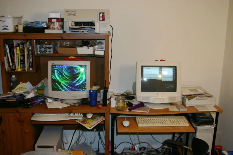two computer screens sitting next to each other on top of a desk