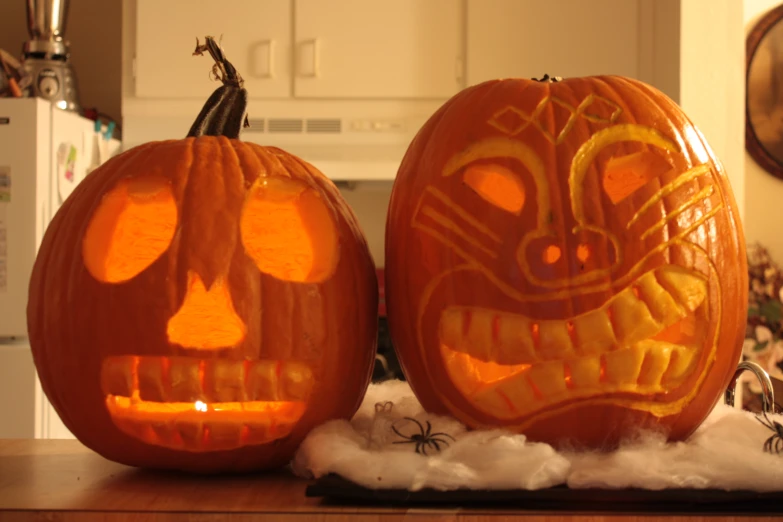 two carved pumpkins sitting on top of a counter