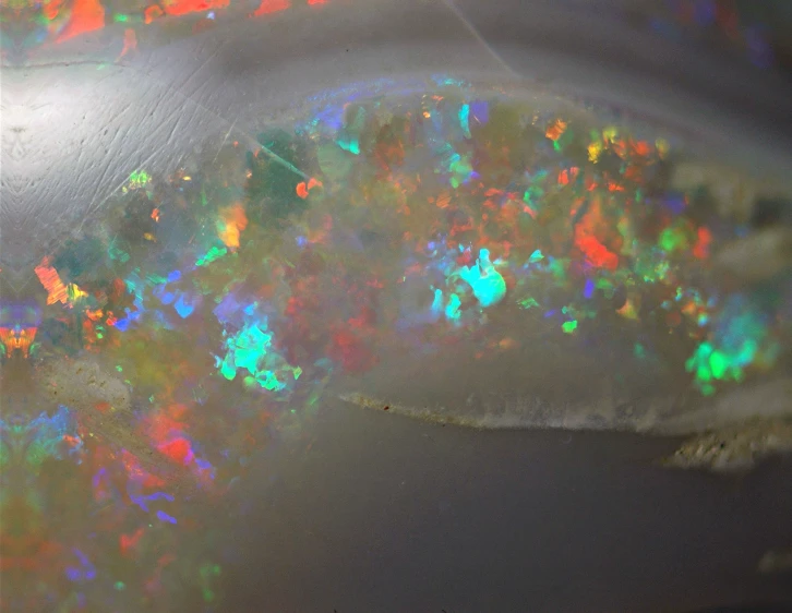 the top view of an opal with bright colors and small bubbles