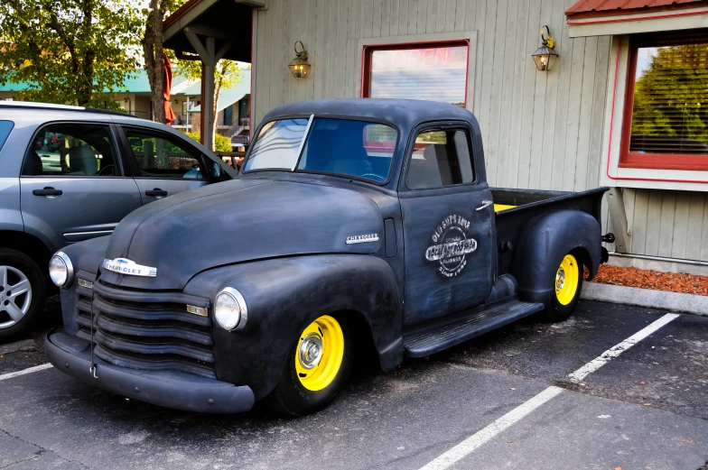 an antique truck is parked next to two other cars