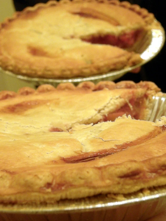 several pies on metal pans one is uncooked