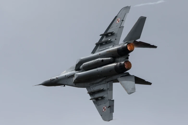 an airplane flying through a cloudy sky with smoke coming out