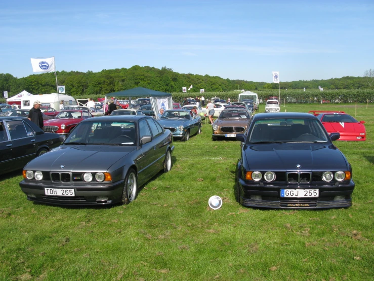 a few cars on a grassy field and a white ball