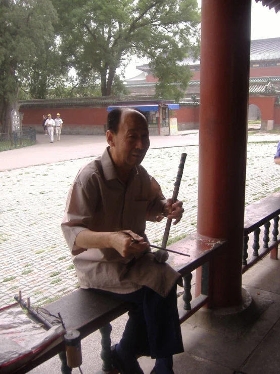 a man sits on a bench at the side of a building