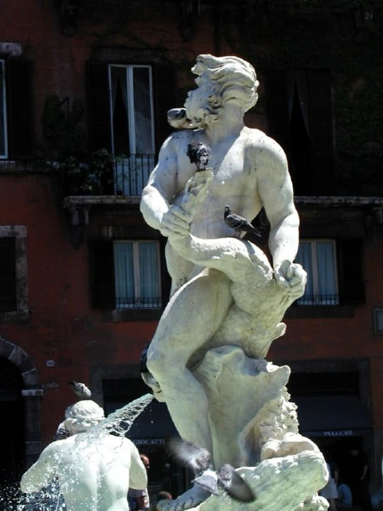 an old statue of a boy and a dog is near a fountain