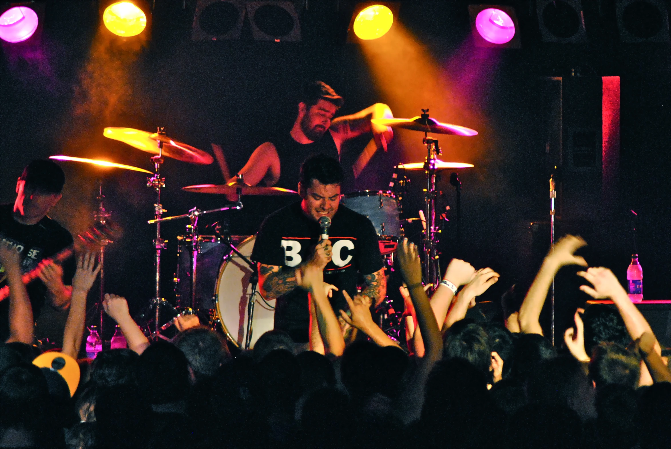 people are on stage and clapping as the band performs