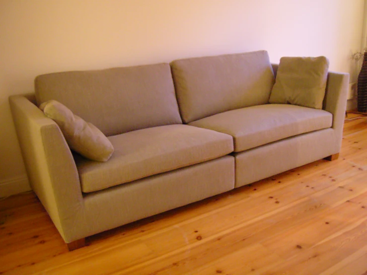 a couch and chair on the floor next to the wall