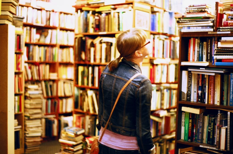 woman looking into books in liry filled with books