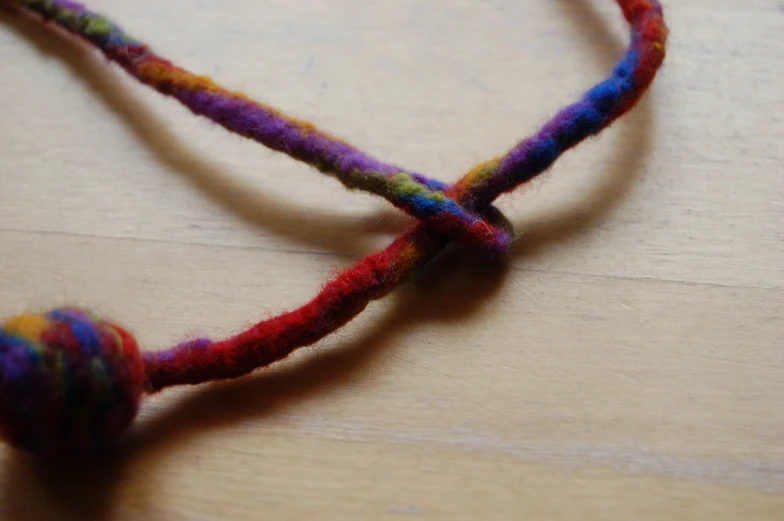 a string with a knot in the middle on top of a wooden table