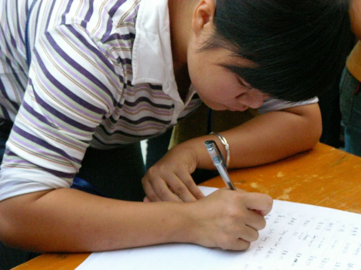 a person writing in a notebook with a pen