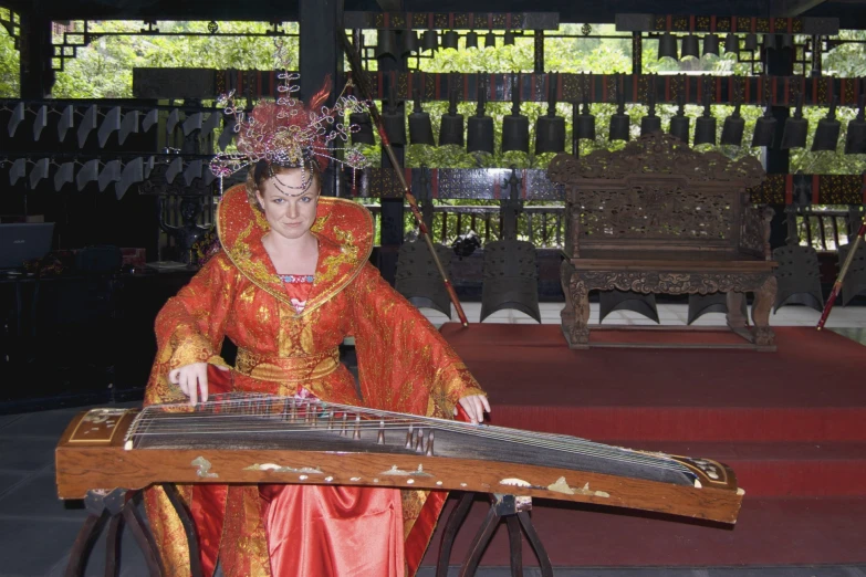 woman in orange costume with instrument on stage