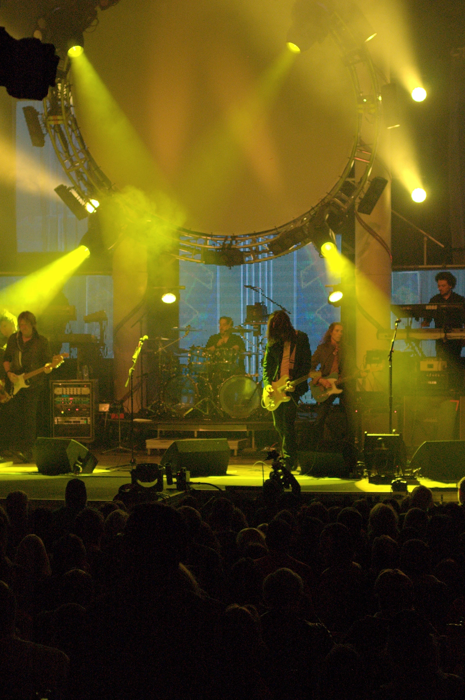 three musicians on stage in front of a large crowd