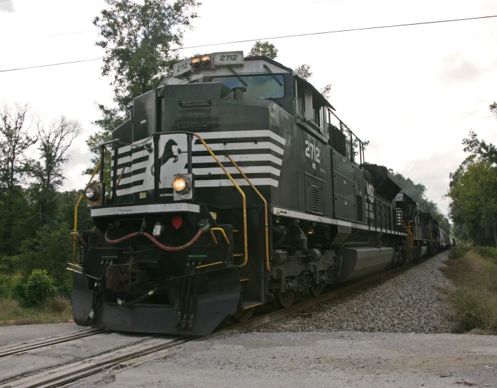 a train is coming down the tracks near a grassy area