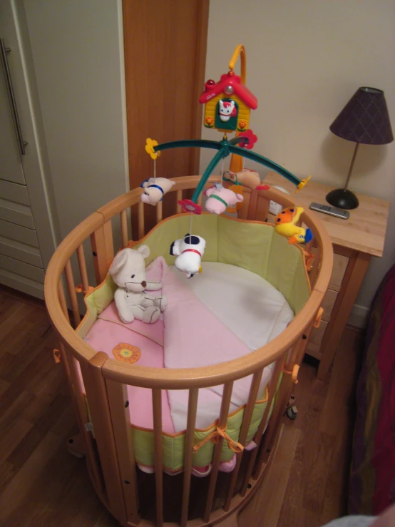 a crib with some toys and a stuffed animal in the corner