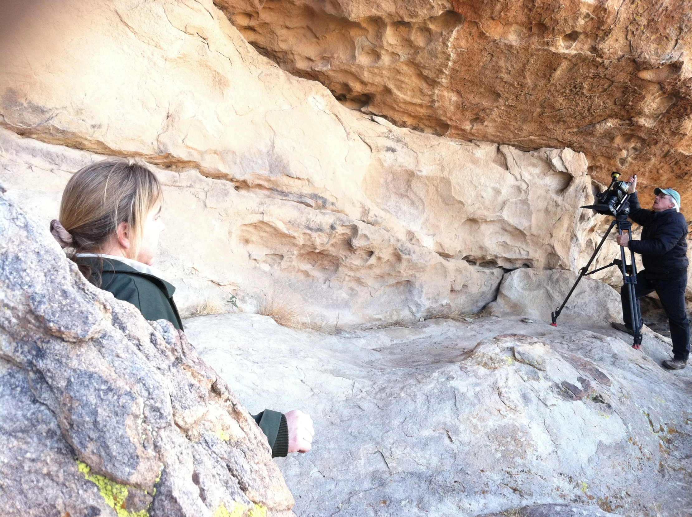 man and woman standing in a cave with rocks