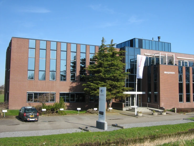 two cars are parked outside a brown brick building