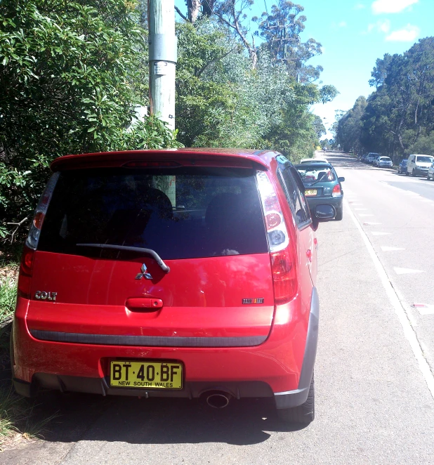 an orange and black minivan sits on the side of the road