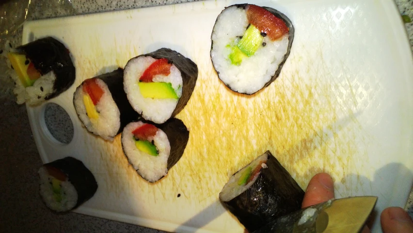 sushi with sauces and vegetables are on a chopping board
