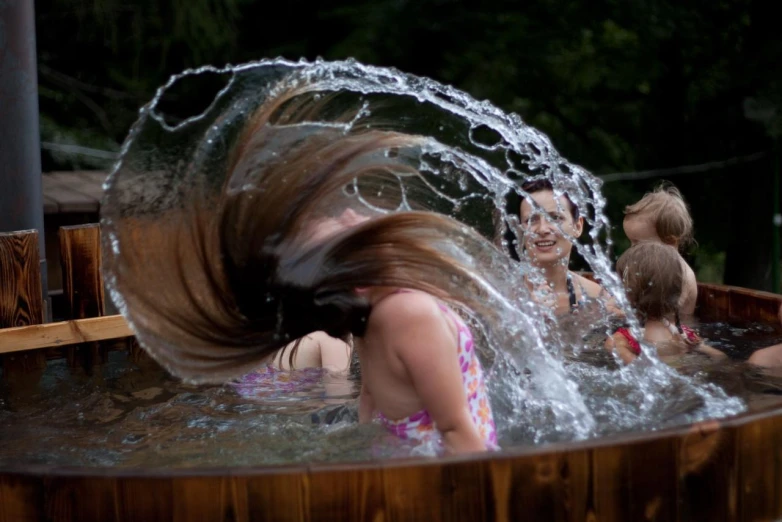 a group of young women playing with water in a pool