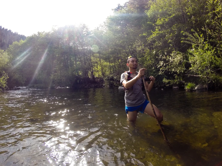 a man standing in water with a stick