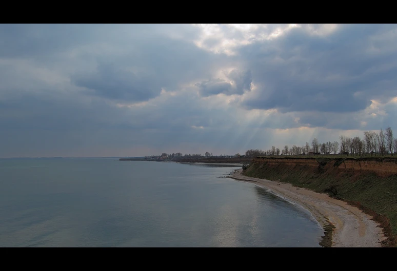 a body of water with some trees and other shore areas