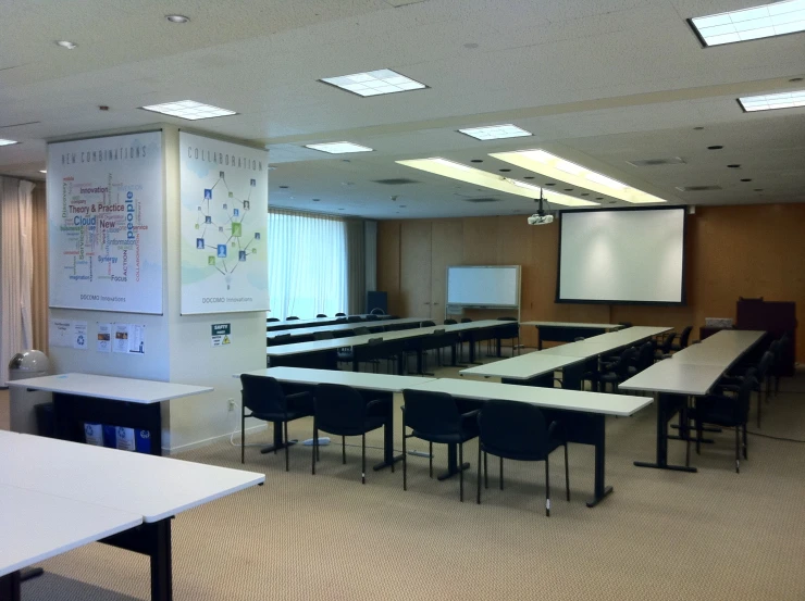 a classroom has a long table, chairs and projector