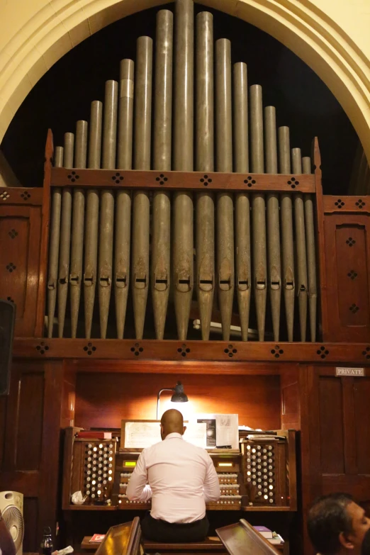 an organ inside of a church with people watching