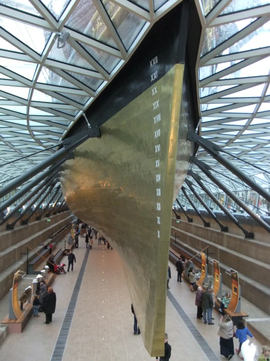 several people in a train station near a large golden boat