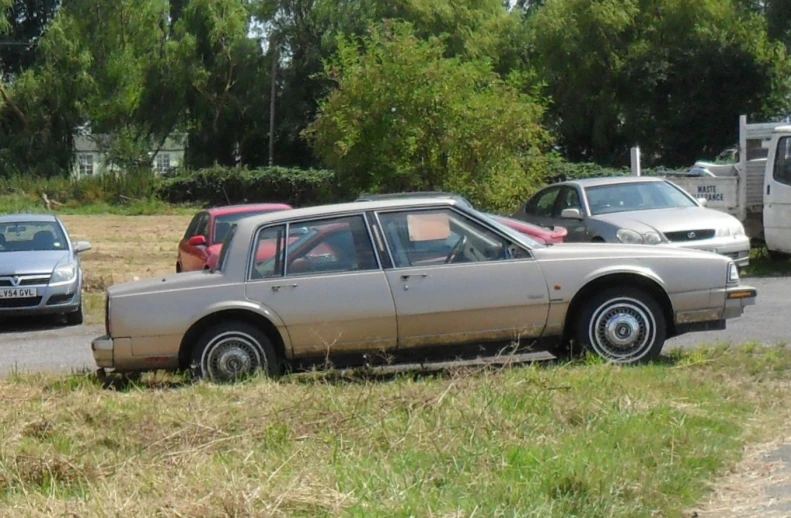 a brown car with red seats parked at the curb