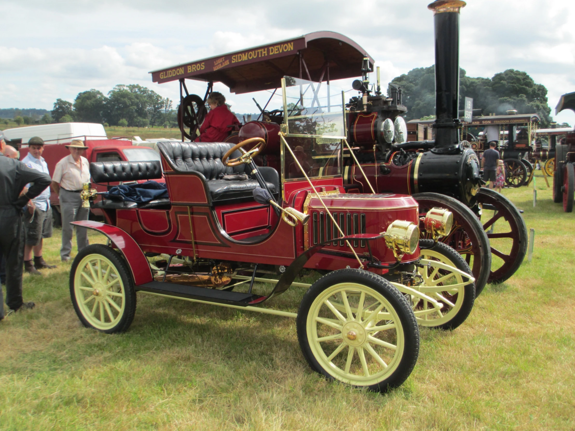 an old red fire engine parked in the grass