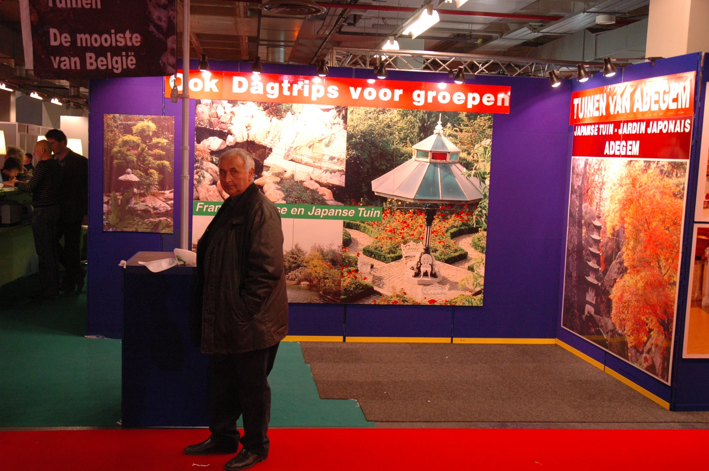 a man standing in front of several paintings