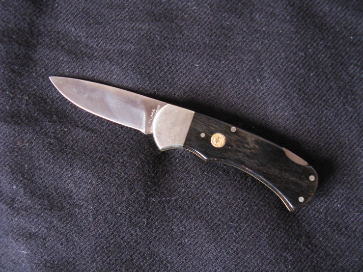 a knife on the ground with a gold ring on it