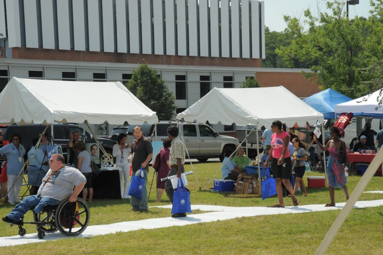 a handicapped man in a wheel chair walks through an event