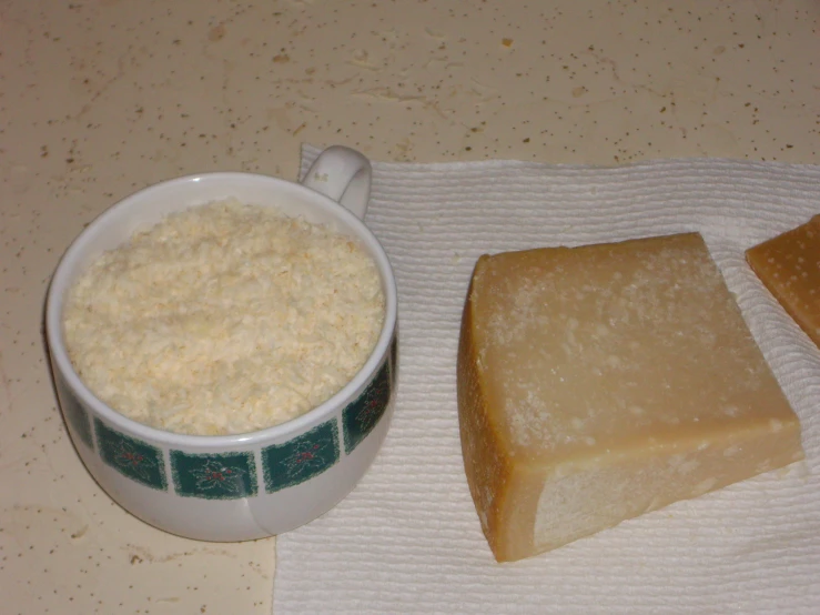 two pieces of bread are beside a bowl of cheese grits