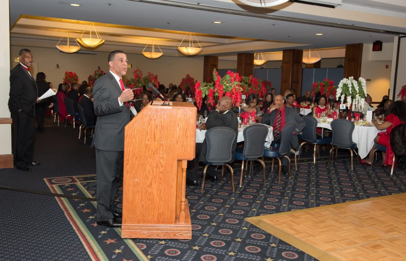 a man standing at a podium in front of a crowd