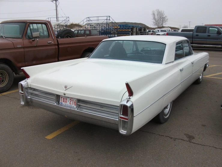 an old car is parked next to a older pickup truck