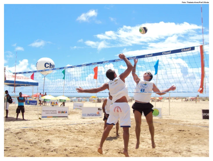 two young men play beach volleyball against each other