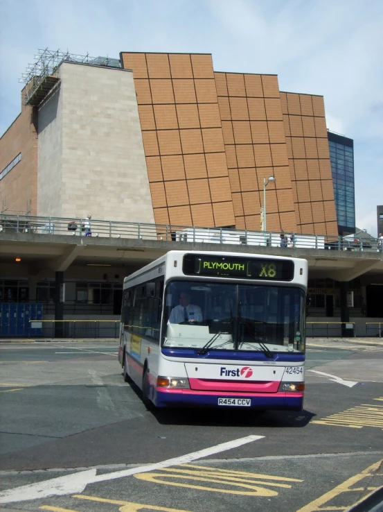 a bus is passing under a bridge with a sky background