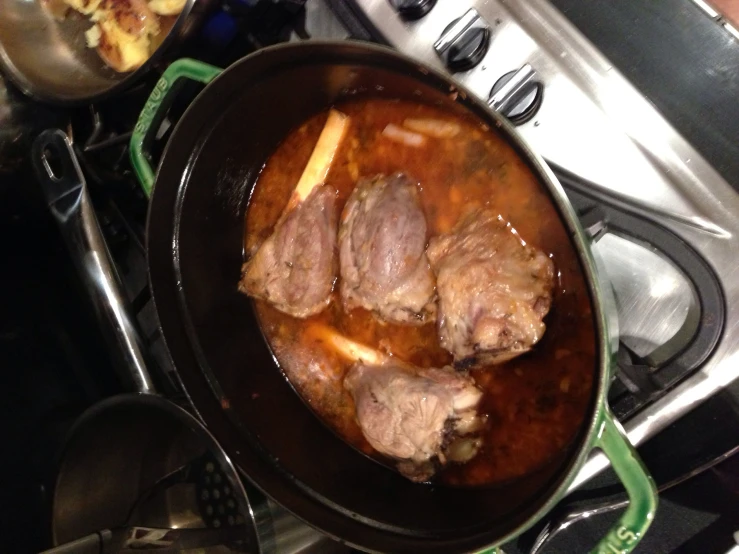a close up of some meat in a pan on the stove
