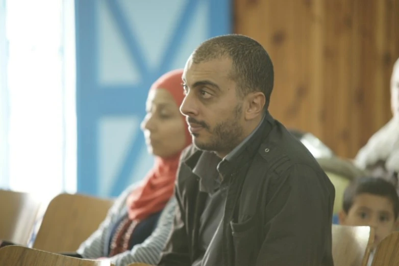 a man is looking at his lecture while others watch